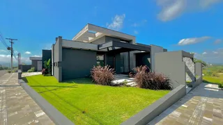 Fachada moderna de uma casa em Lajeado com jardim gramado e paisagismo.