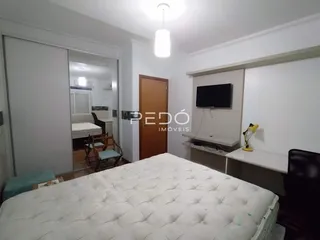 Foto de um quarto com cama grande e paredes brancas.
