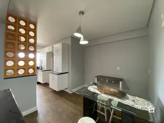 Hall de entrada com revestimento decorativo e armários brancos.
