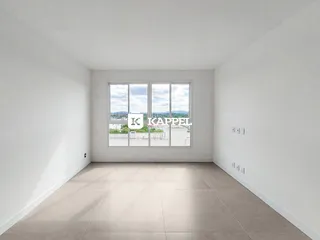 Uma sala ampla com grandes janelas que oferecem uma vista panorâmica da paisagem.