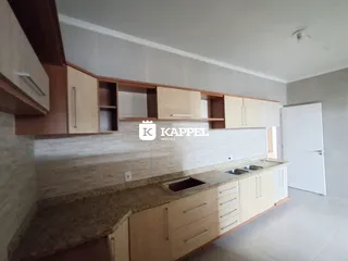 Cozinha com armários de madeira e bancada clara.