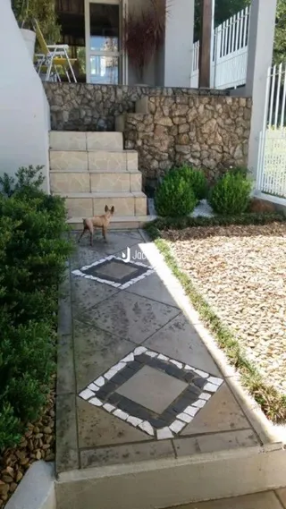 Parede de pedra e piso de concreto no exterior da propriedade.