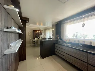 Vista da cozinha moderna com armários e grande janela.