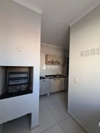 Interior de uma sala com paredes brancas e piso claro.