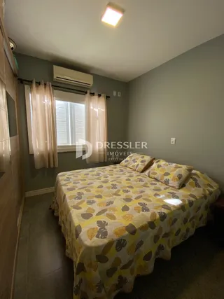 Quarto com cama e janela em ambiente interno.