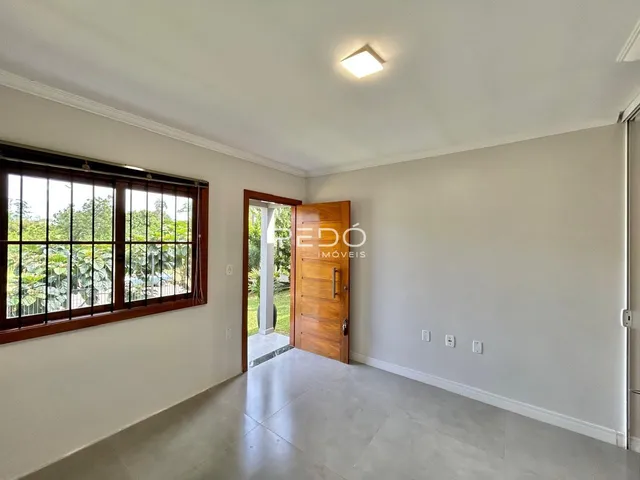 Interior de uma sala com janela e porta de madeira.