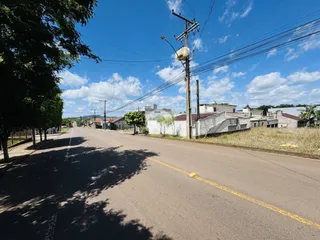 Vista da rua em Lajeado, Brasil, mostrando residências e vegetação ao longo da via.