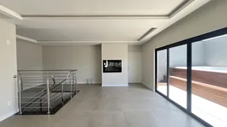 Hall com escada e portas de vidro que dão para o exterior.