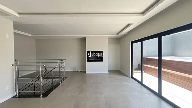 Hall com escada e portas de vidro que dão para o exterior.