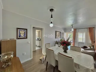 Vista de uma sala de jantar com mesa e cadeiras em um imóvel no Brasil.