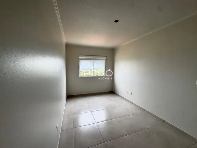 Vista interna de um corredor com piso de cerâmica claro.