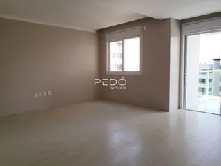 A sala apresenta um ambiente amplo com piso de madeira clara.