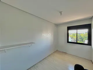 Ambiente interno com paredes brancas e piso de madeira clara.