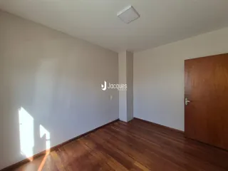 Foto de um ambiente interno com piso de madeira e paredes brancas.