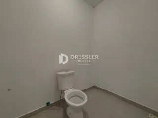 Foto interna de um banheiro com vaso sanitário e piso claro.