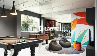 Sala de estar com mesa de bilhar e grandes janelas.
