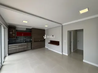Sala de estar e cozinha com piso claro e armários de madeira.