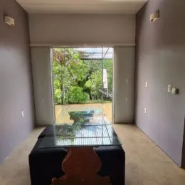 Ambiente interno com vista para a área externa verde.