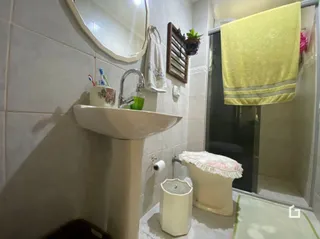 Banheiro com pia e toalha na parede