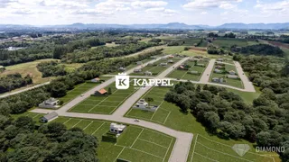 Vista aérea de um loteamento com diversas propriedades e áreas verdes.