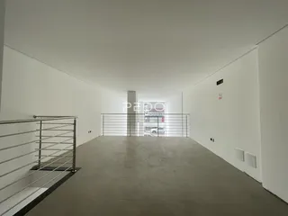 Interior de um corredor longo com piso de concreto.