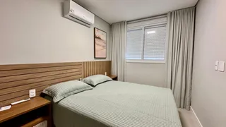 Quarto com cama e cabeceira de madeira.