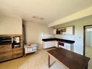 Foto de uma cozinha com armários brancos e bancada escura.