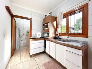 Uma cozinha com bancada e janela de madeira em um imóvel em Lajeado.
