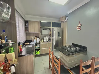 Foto de uma cozinha com armários de madeira e eletrodomésticos em Lajeado.