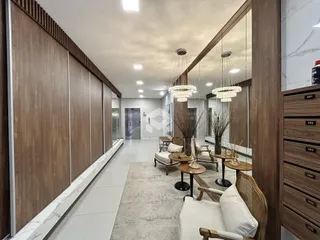 Hall de entrada moderno com painéis de madeira e área de estar.