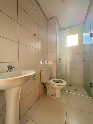 Foto do interior de um banheiro com pia e vaso sanitário.