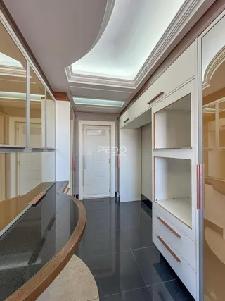 Hall de entrada com revestimento branco e piso escuro em um imóvel no Brasil.