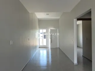 Vista do corredor interno de uma residência com piso de cerâmica.