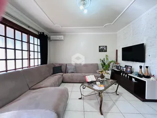 Uma sala de estar ampla com um sofá grande e grandes janelas.