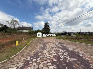 Foto da entrada de uma propriedade em Lajeado, Brasil, mostrando uma estrada de paralelepípedos.