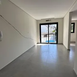 Hall de entrada com paredes brancas e porta de saída.