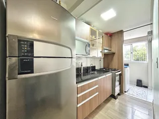 Cozinha moderna com armários de madeira e eletrodomésticos de aço inoxidável.