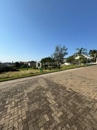 Vista da fachada de uma propriedade em Lajeado, Brasil, com área pavimentada na frente.