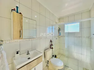 Banheiro com piso e azulejos brancos na Lajeado, Brasil.