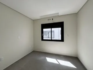 Vista interna de um cômodo com paredes brancas e piso de cerâmica.
