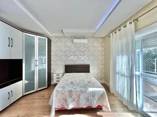 Quarto com cama e armários brancos em ambiente claro.
