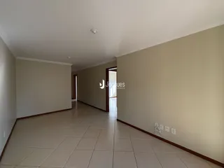 Corredor interno de uma residência com piso de cerâmica.