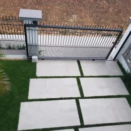 Foto de uma área externa pavimentada com um portão de metal.