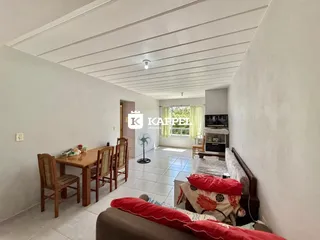 Uma sala de estar com mesa de jantar de madeira e sofá.