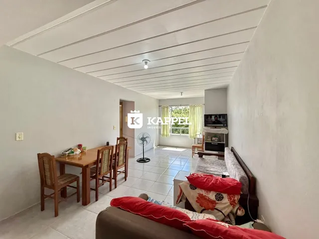 Uma sala de estar com mesa de jantar de madeira e sofá.