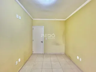 Corredor com paredes amarelas claras e piso de cerâmica.