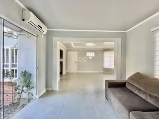 Vista de um corredor interno com porta de vidro e sala adjacente.