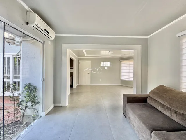 Vista de um corredor interno com porta de vidro e sala adjacente.