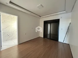 Interior de uma sala com piso de madeira e porta de vidro.