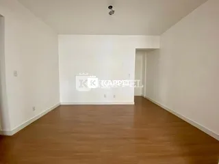 Foto de um ambiente interno com paredes brancas e piso de madeira.